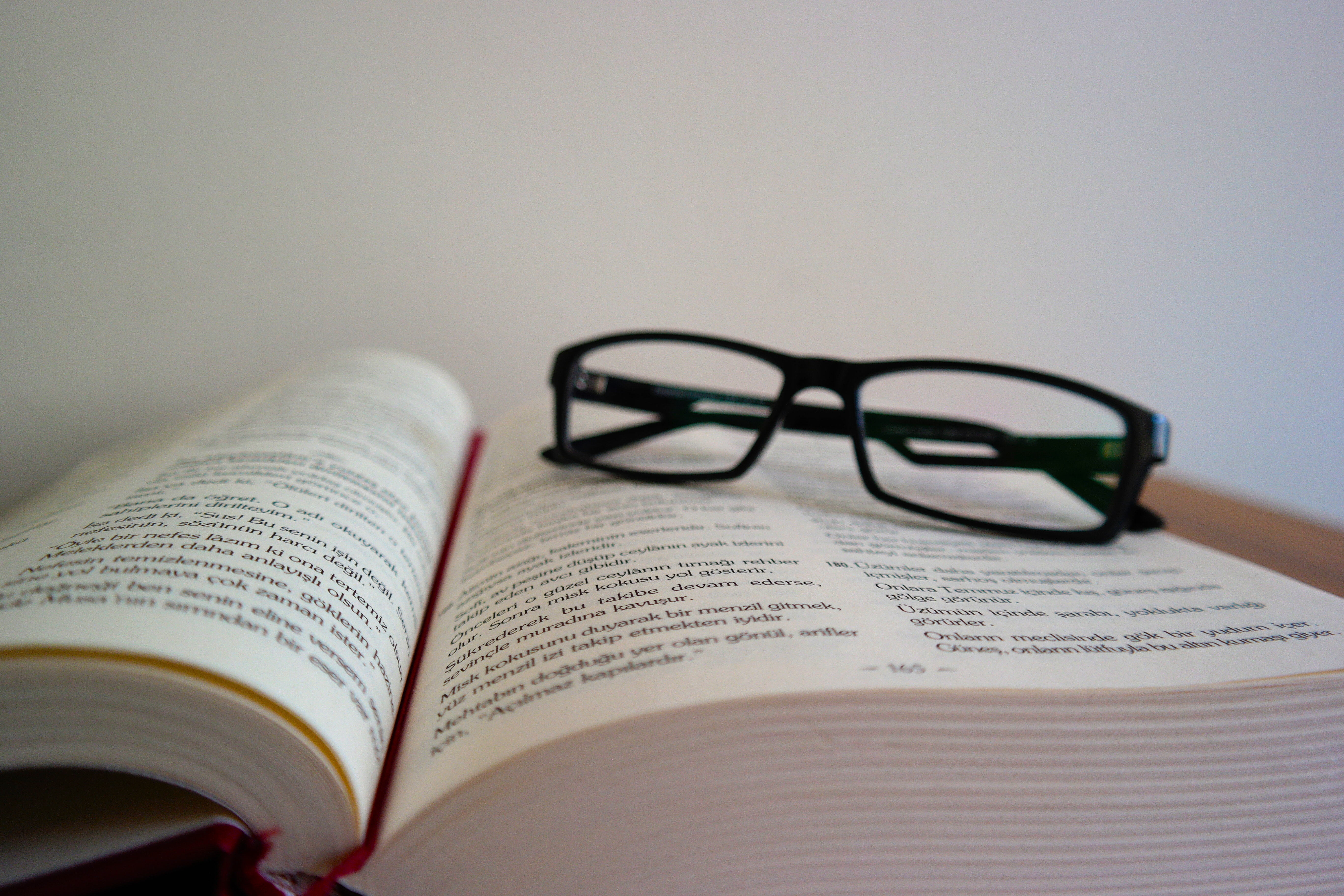 libro abierto a modo de lectura - gafas negras encima del libro